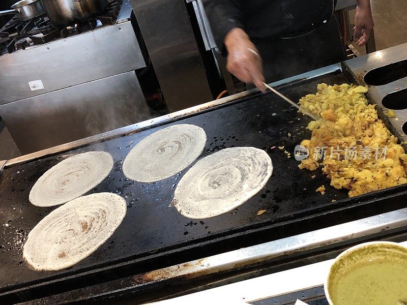 酒店餐厅厨师在厨房热板上制作美味的印度薄饼