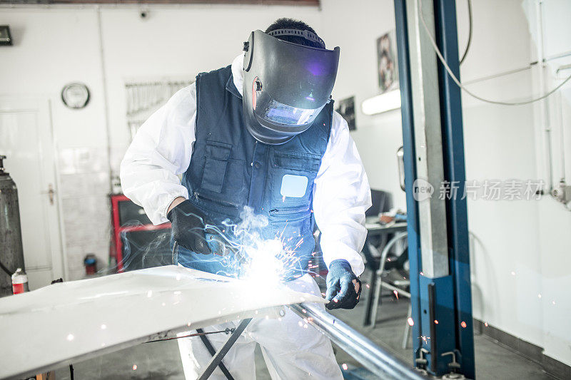 车身修理厂技师使用米格焊机修理在车身修理厂损坏的汽车零件
