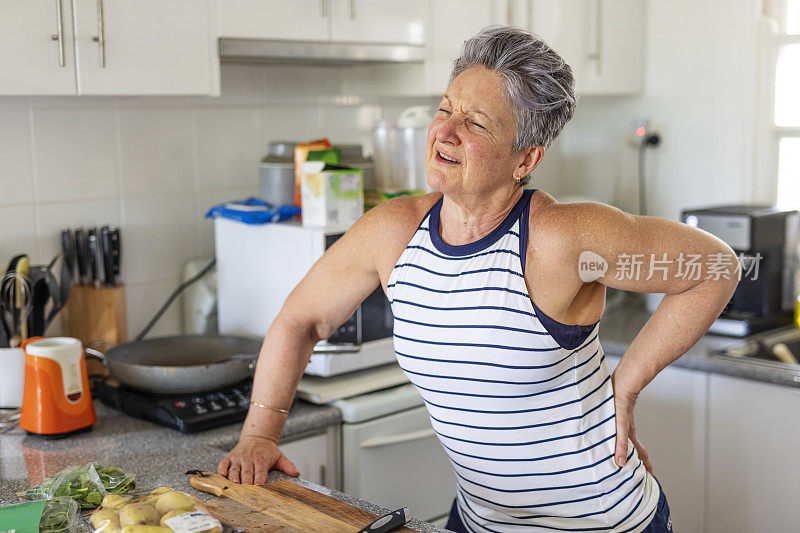 厨房里背疼的资深女性