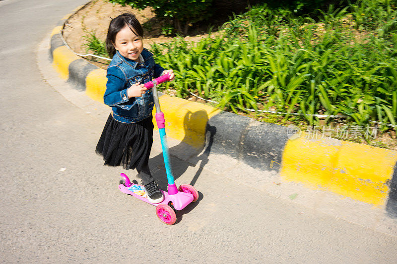 一个小女孩在玩滑板车