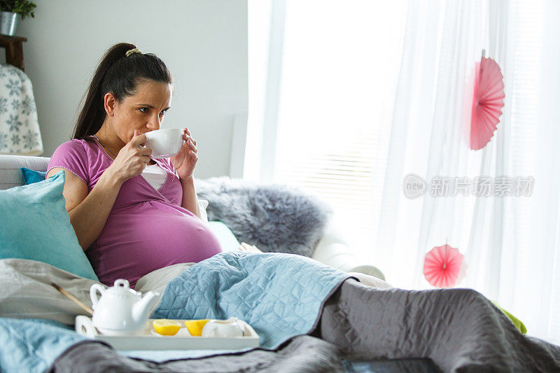 孕妇在床上喝茶休息