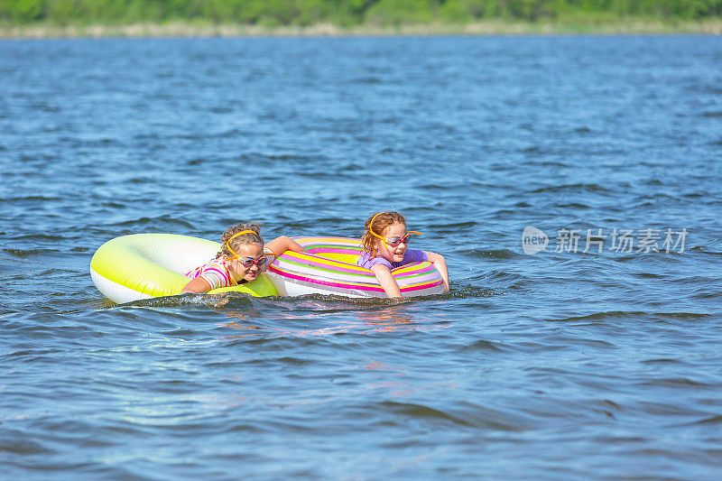 两个女孩在湖上玩充气玩具