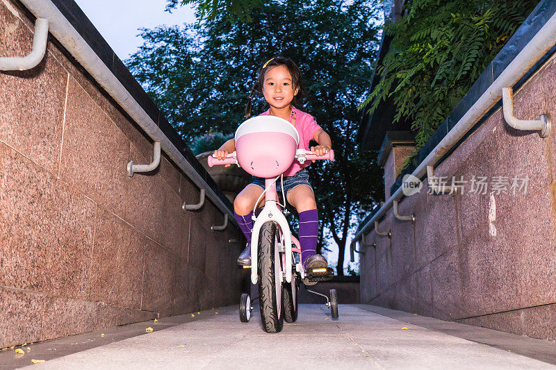 一个小女孩在学骑自行车