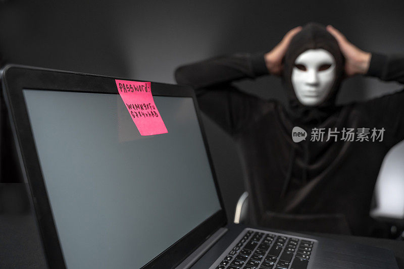 无能的黑客把脑袋放在电脑后面，电脑上有很强的密码