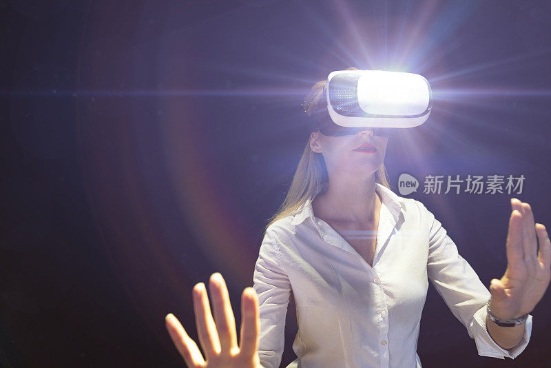 年轻女性佩戴VR眼镜，与虚拟现实互动，娱乐和创新的技术理念