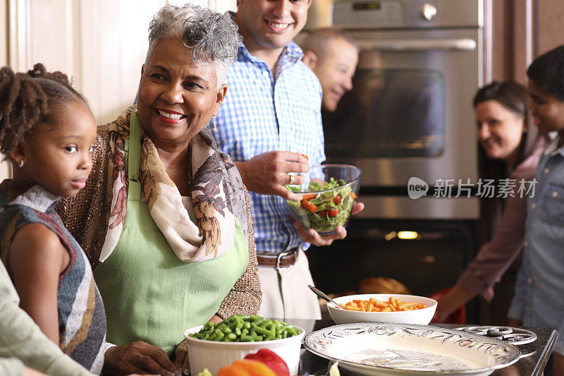 多样化的家庭在家庭厨房里烹饪感恩节晚餐。