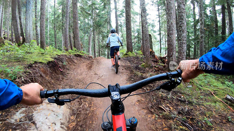 山地自行车手沿着泥泞的小路穿过森林