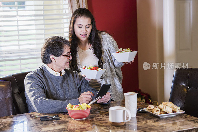 西班牙男人和成年女儿，在看手机