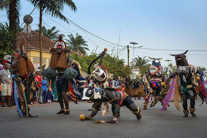 比绍狂欢节上，一群戴着传统面具的男子在跳舞。
