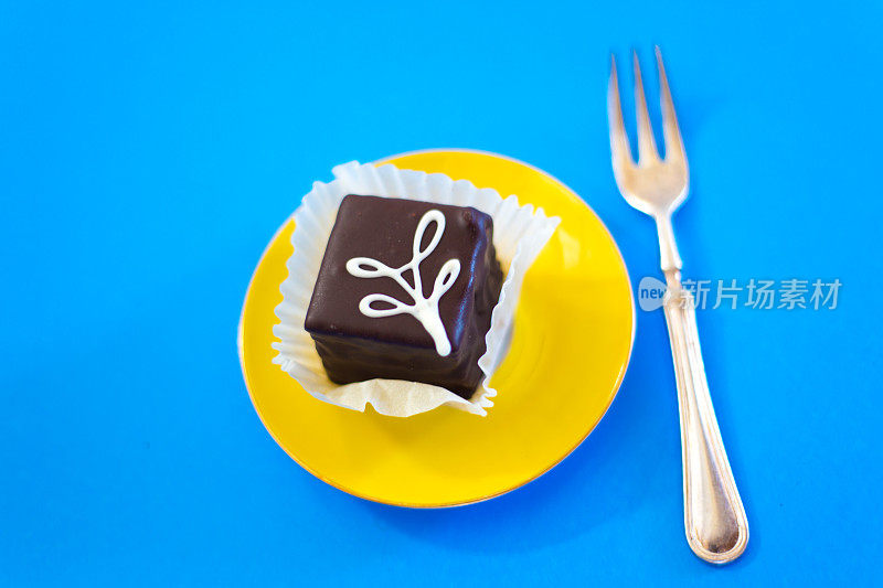 黄色餐盘，蓝色背景的巧克力小蛋糕