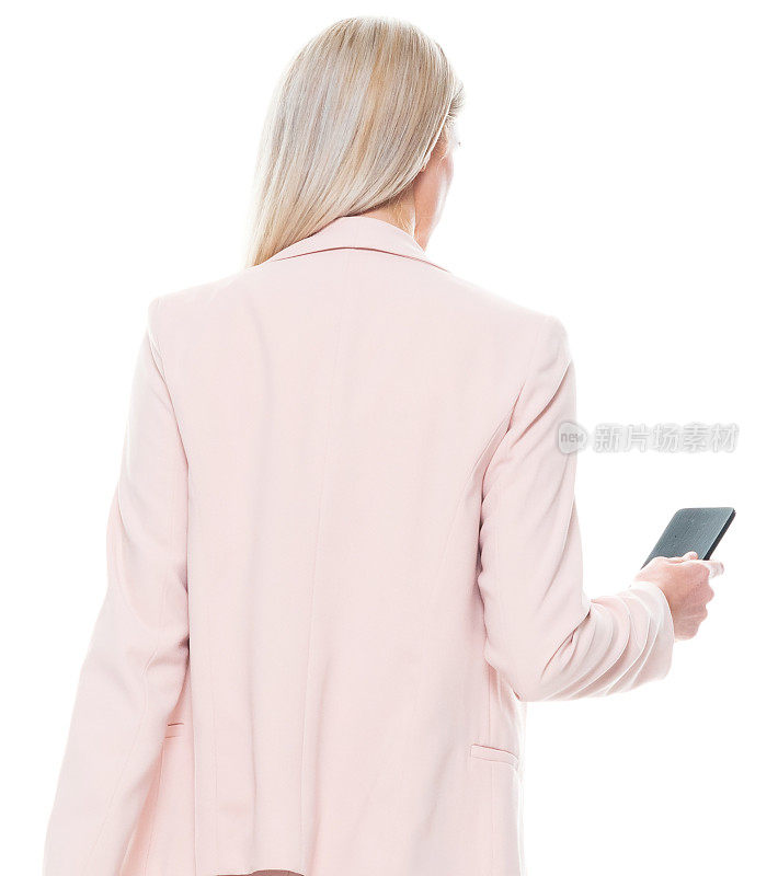 白人女商人穿着商务休闲装，手持钱包，使用智能手机，站在白色背景前