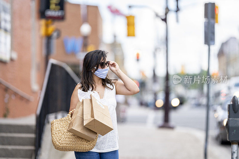 一名西班牙妇女戴着防护面具在市中心购物