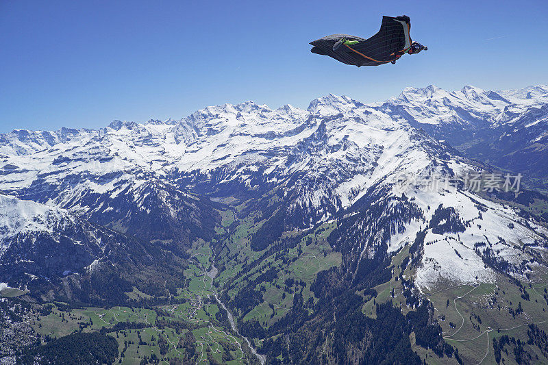 翼装飞行员在山景之上翱翔