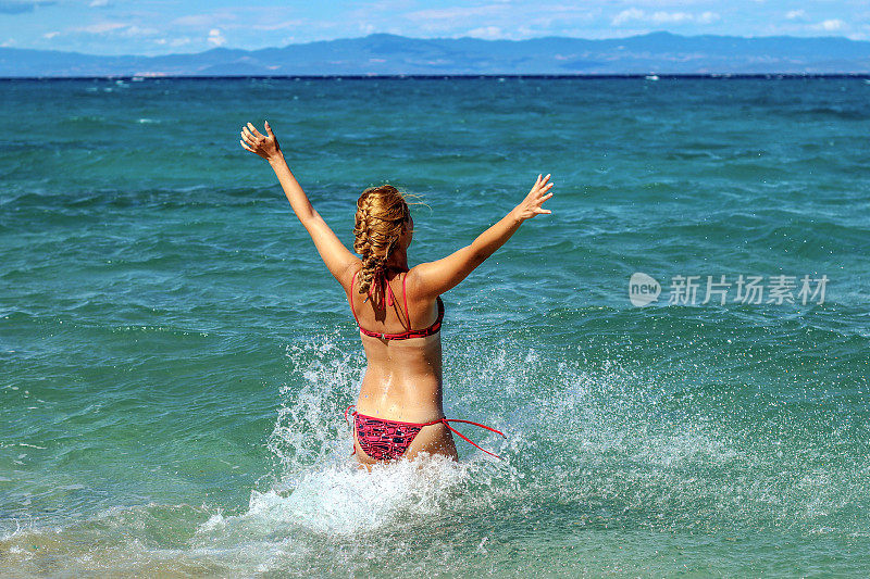 年轻女子享受在海滩上的一天