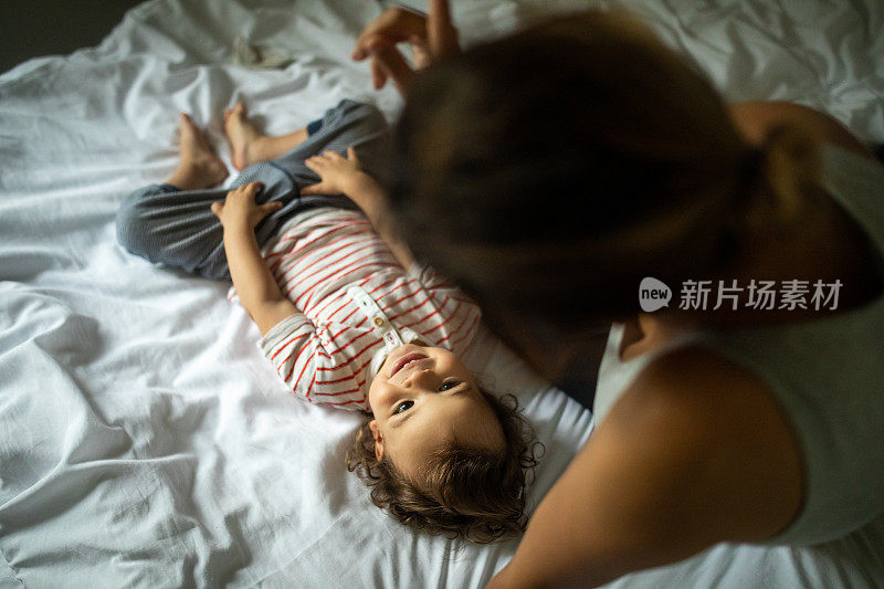 母亲和儿子享受时间一起在床上清晨