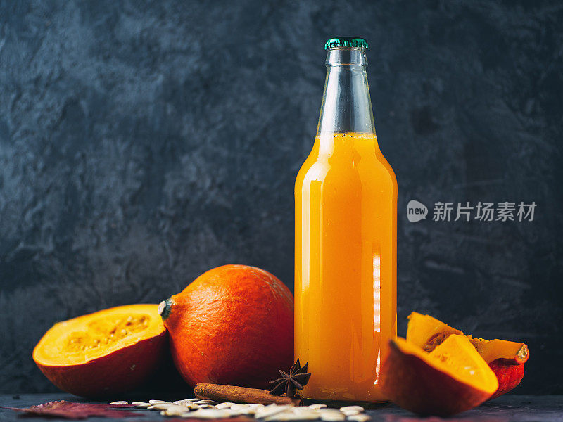 一瓶自制的南瓜汁，桌上放着新鲜的南瓜与拷贝空间。健康的天然饮料