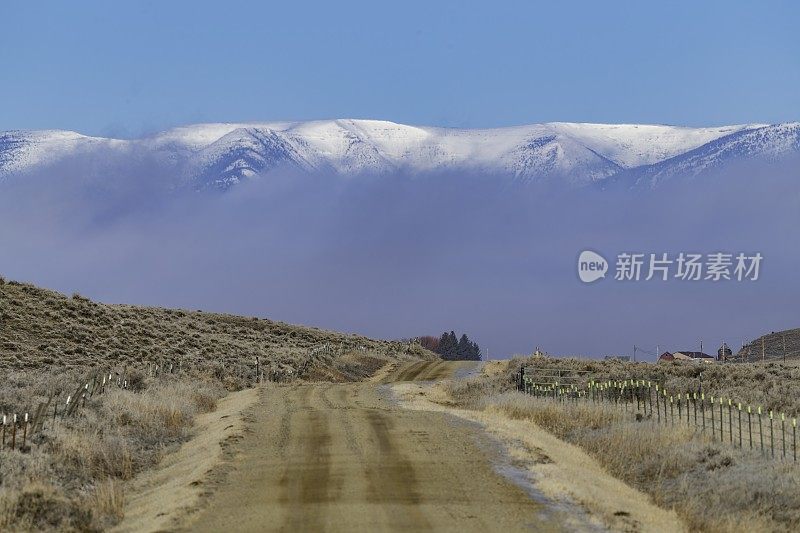 有雾和山脉背景的乡村道路