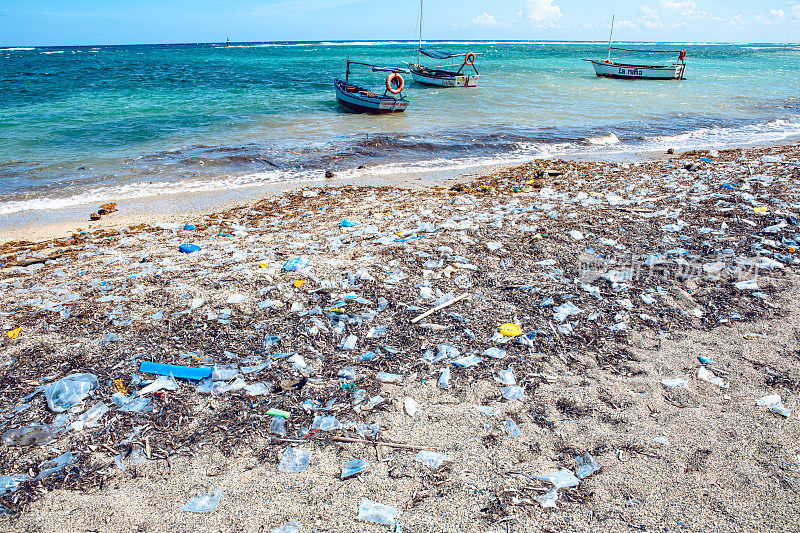 热带海域海滩上的严重塑料污染。海滩上的垃圾与蓝色的海洋背景。(古巴)