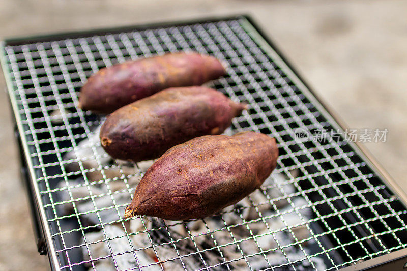 木炭烤炉上的日本红薯。红薯的果肉呈乳白色，在烹饪后会变成黄色。含有纤维，硫胺素，钙，钾和维生素A和C。