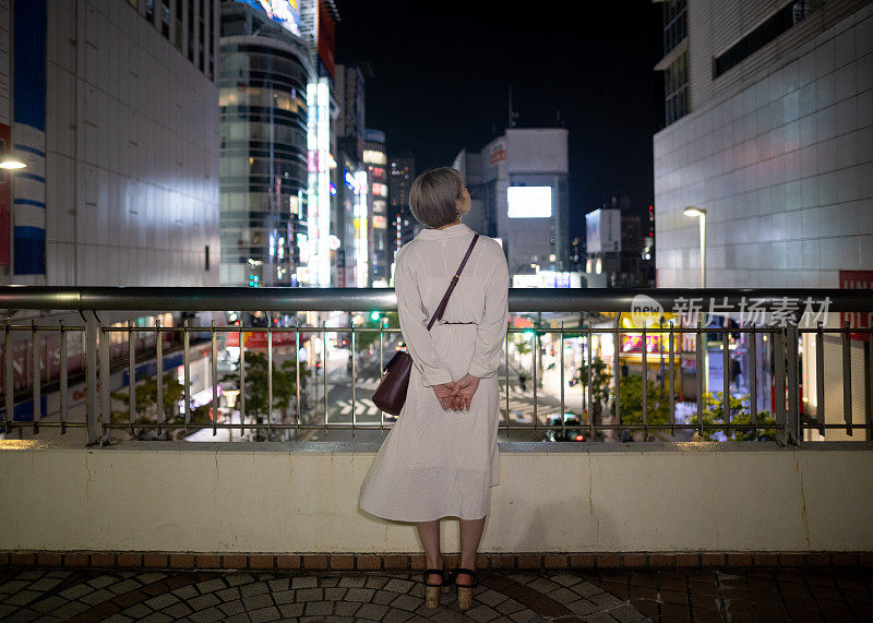 年轻女子从脚灯看夜景