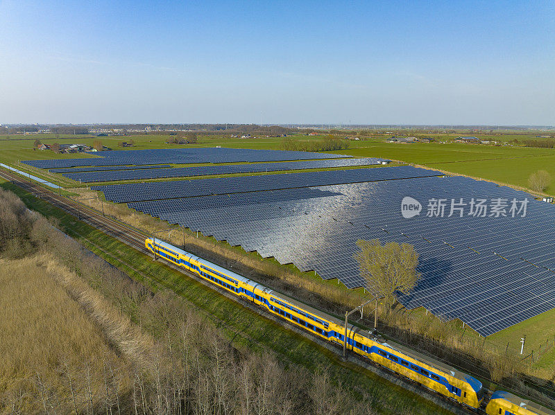 荷兰铁路公司的火车驶过一片太阳能电池板的区域