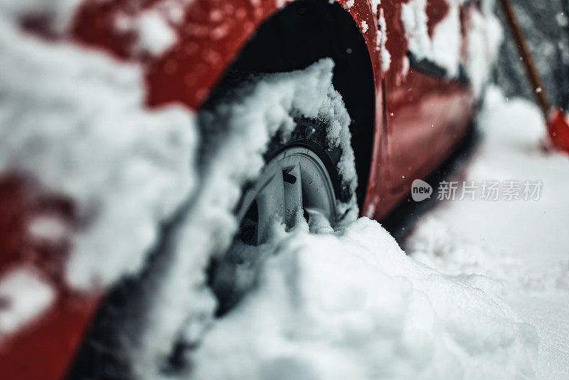 冬季轮胎。细节汽车轮胎在冬天的道路上覆盖着雪。