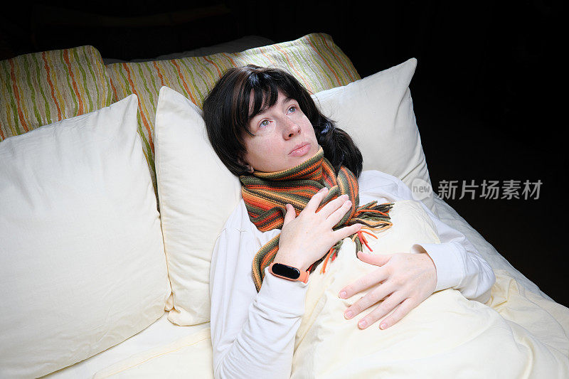 有感冒或流感症状的女性正躺在床上