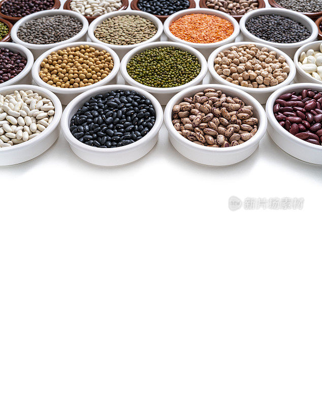 干燥的豆类在碗中组合在白色的角度，包括小扁豆，鹰嘴豆，大豆和大豆