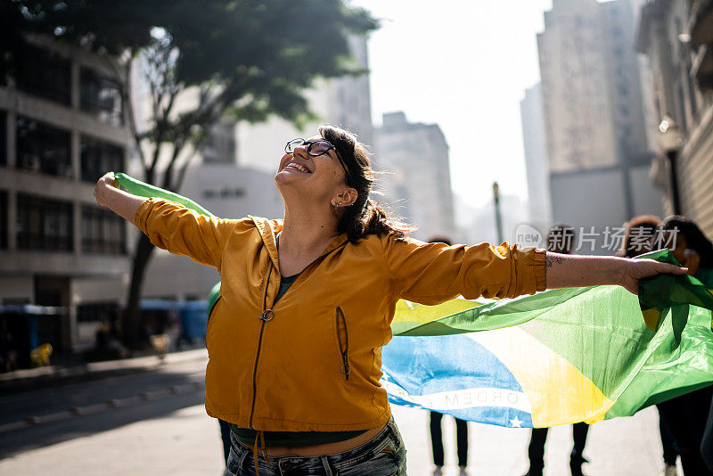 年轻女子举着巴西国旗在户外庆祝