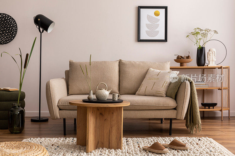 家居和舒适的客厅内部米色沙发，植物，书架，茶几，绒线地毯，模拟海报框架，边桌，植物和优雅的装饰米色墙。家居装饰。模板。