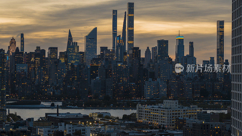 从长岛市看曼哈顿摩天大楼的夜景，夜晚灯火通明。