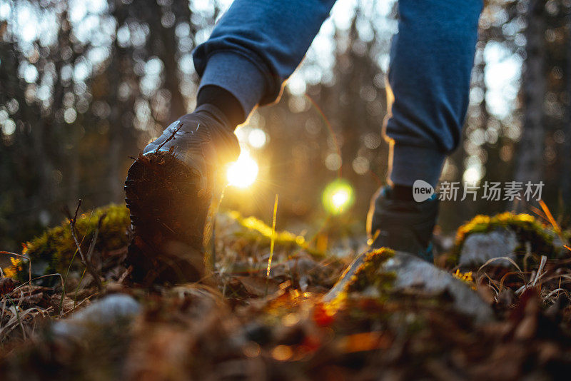 年轻女子徒步旅行者的腿走在小径上的草原