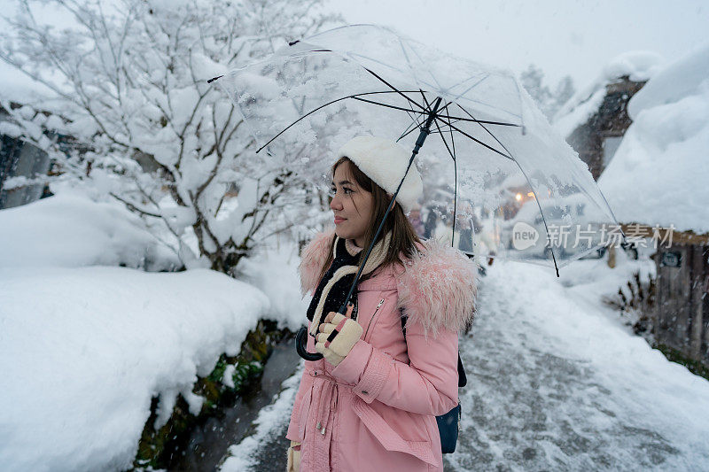 美丽的女游客们享受着白川村的旅行，冬天的日本有厚厚的积雪