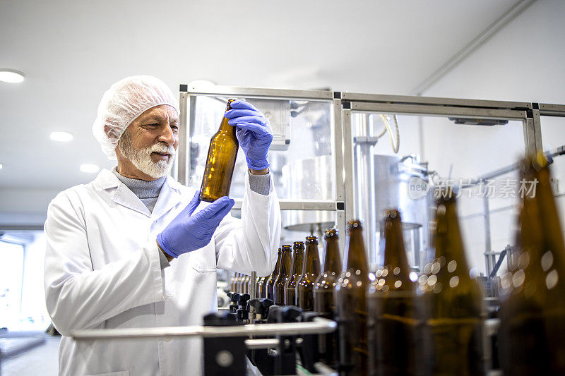 在饮料厂控制啤酒瓶生产的有经验的工人。