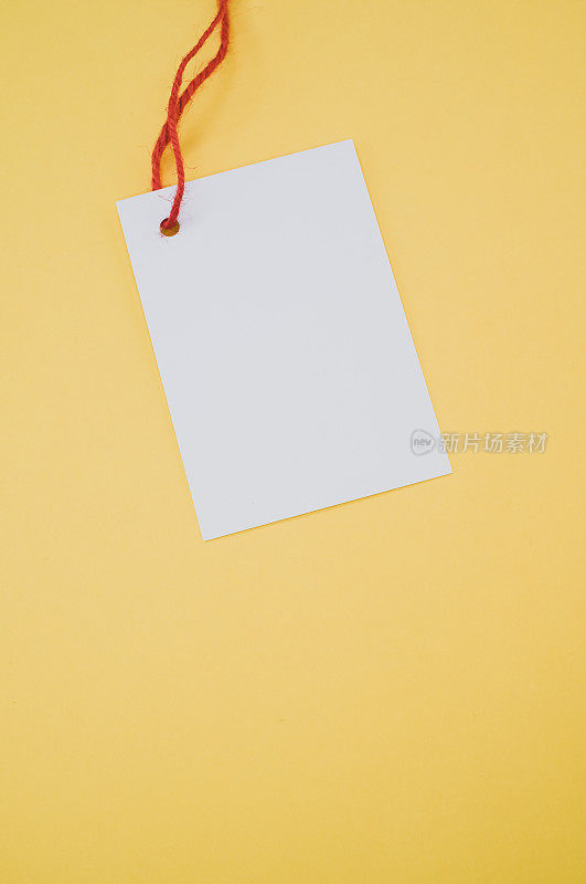 垂直拍摄一张黄色背景上有红线的白色卡片