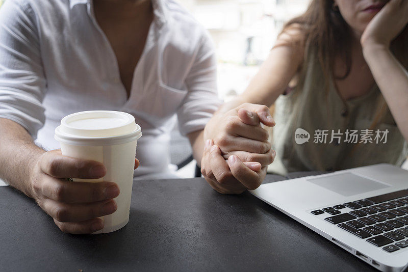 幸福的情侣坐在咖啡馆里用笔记本电脑上网