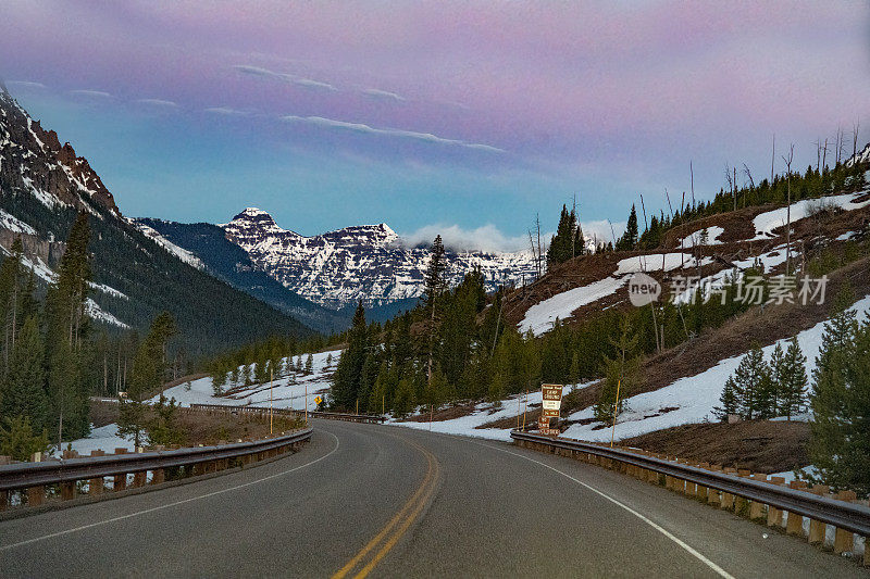 在美国西部的北美黄石生态系统中，黎明时分从东方接近蒙大拿州库克城的高速公路场景