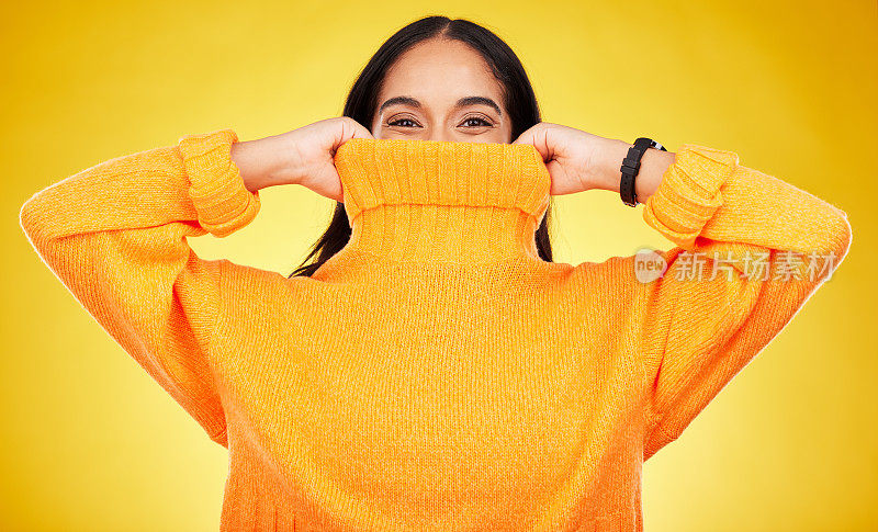 快乐，一个女人的封面和肖像，在黄色的背景上孤立的运动衫在一个工作室。隐藏，冬天和一个女孩拿着一件套头衫为掩护，温暖和坏天气的背景
