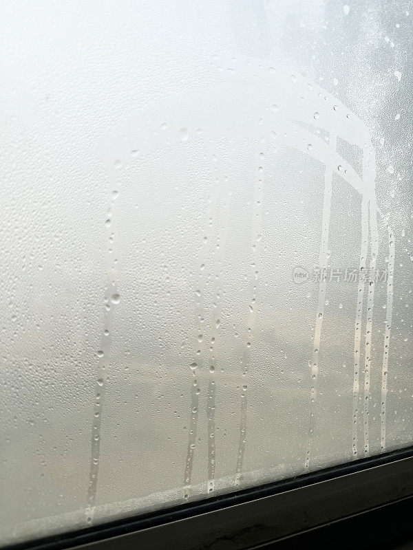 全画幅的白色彩绘木玻璃窗玻璃被凝结，水滴痕迹，霉菌和潮湿的冬天，重点在前景