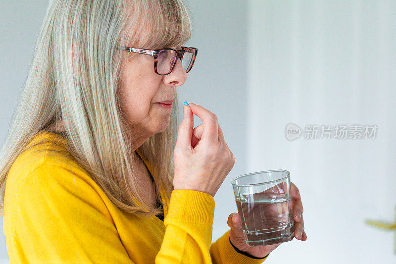 一位老年妇女正在服用药物