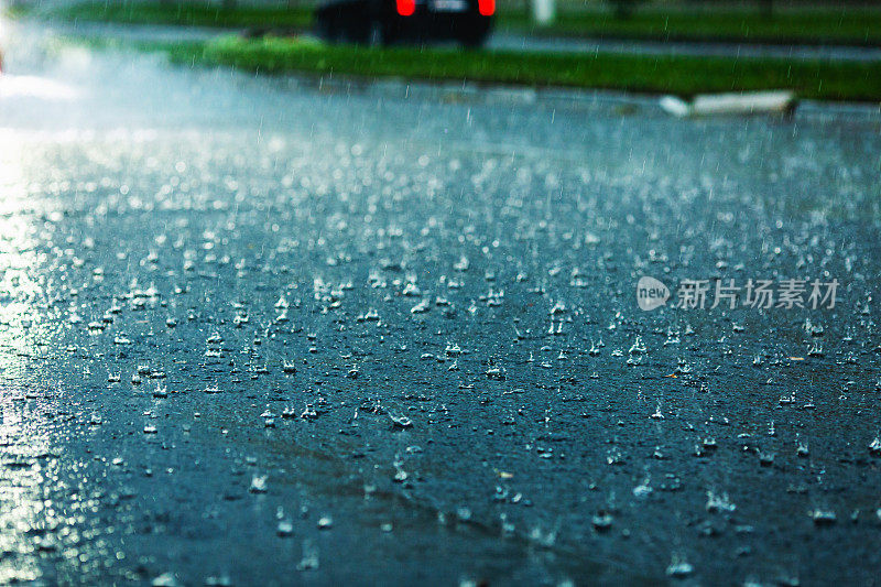 汽车驶过水坑。水溅。坏天气。暴雨