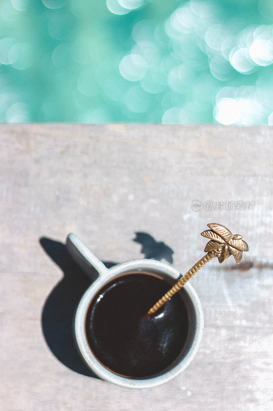 咖啡杯与美丽的勺子与热带背景