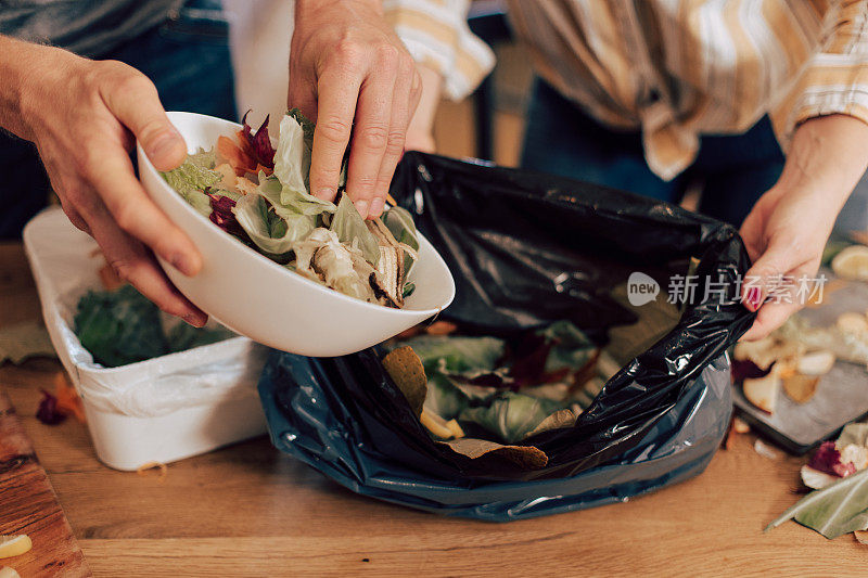 这对夫妇堆肥他们的有机剩余物的特写