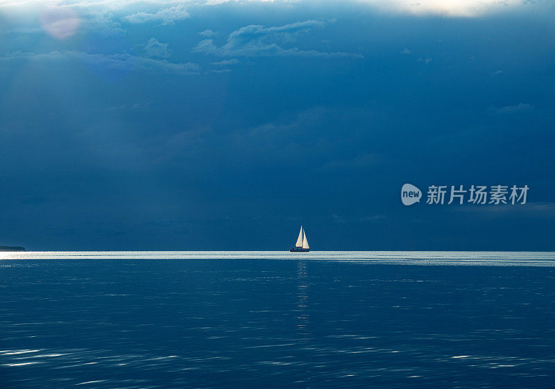 海上的帆船与暴风雨云在地平线上-库存照片