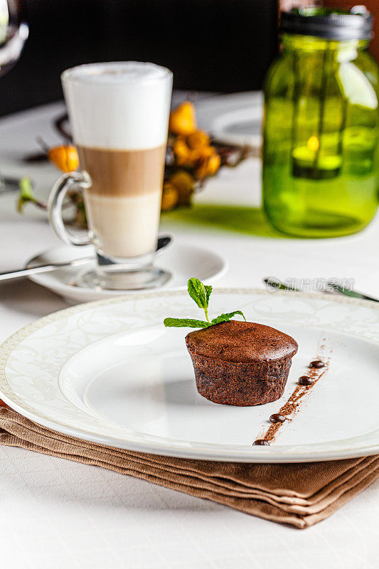 法式料理白色盘子上的巧克力软糖甜点。里面有液态巧克力的烤纸杯蛋糕。背景图像，复制空间文本