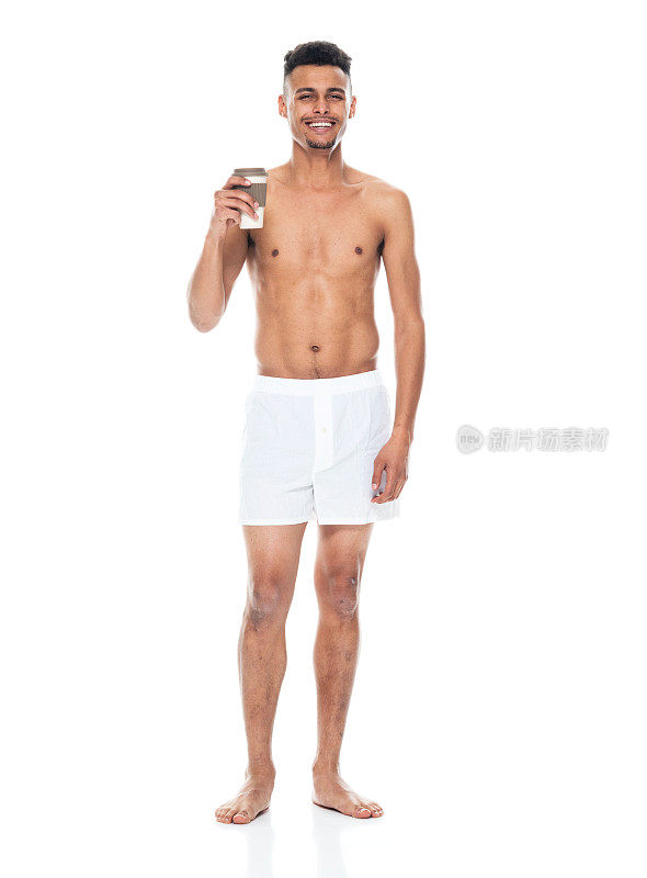 非裔美国青年男性穿着内衣拿着咖啡杯站着