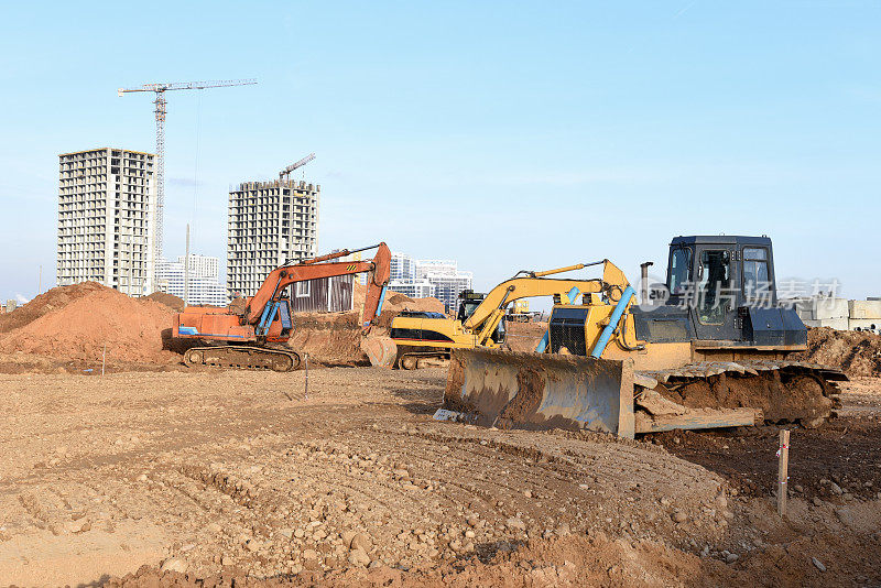 挖掘机和推土机在建筑工地挖土，以安装污水雨水管