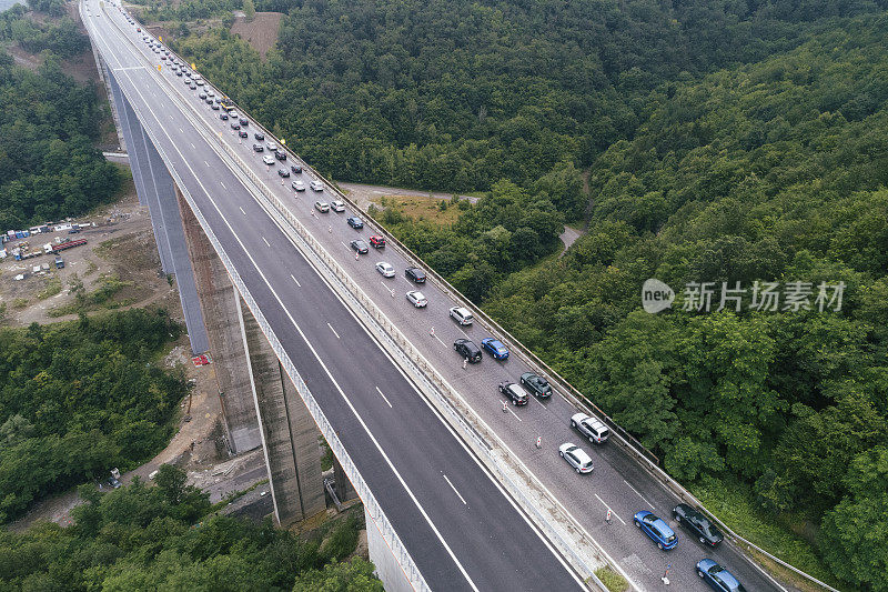 在高峰时间开车穿过交通堵塞。2019冠状病毒病大流行期间，首都城市入口处出现严重交通堵塞的公路桥鸟瞰图。忙碌的生活，俯视图，城市景观。