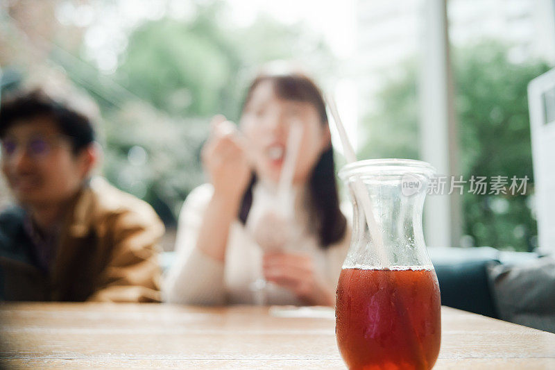 年轻人在咖啡馆里放松的照片，专注于前面的饮料