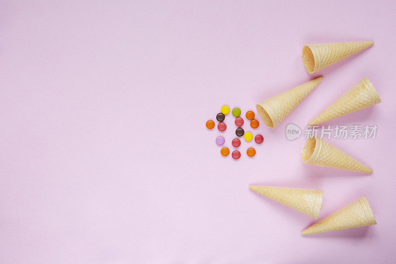 华夫蛋筒冰淇淋和彩色的点缀在粉红色的背景
